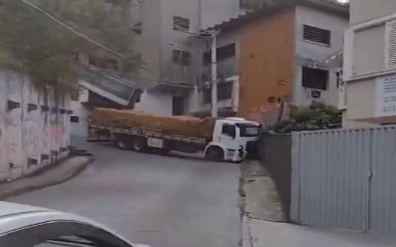 Caminhão colide com muro na curva da 